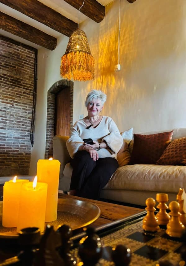 Sára, a SpainAura alapítója, hivatalos idegenvezető és Dalí-szakértő egy sziklafal előtt állva mosolyog.